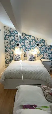 a bedroom with two beds with blue and white flowers at Centre d'énergies in Monteux