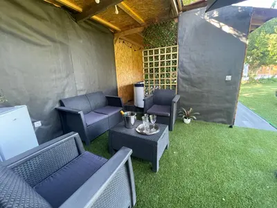 an outdoor patio with chairs and a table and grass at DEPENDANCE PRIVEE - HALTE ROUTE in Le Thor