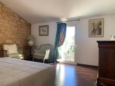 a bedroom with a bed and a window and chairs at Bastide Sainte Agnès in Carpentras