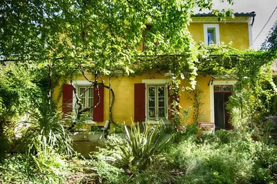 a yellow house with trees and plants in front of it at Bastide Sainte Agnès in Carpentras