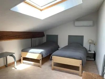 two beds in a room with a skylight at Gîte les Cyprès (Bastide Sainte Agnès) in Carpentras