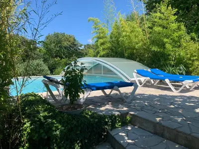 a pool with two chairs and a table and a tent at Gîte les Cyprès (Bastide Sainte Agnès) in Carpentras