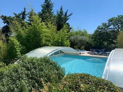 a swimming pool in a yard with trees and bushes at Gîte les Cyprès (Bastide Sainte Agnès) in Carpentras