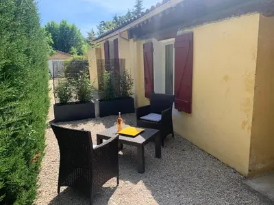 a patio with a table and chairs and a building at Gîte L'Olivier (Bastide Sainte Agnès) in Carpentras