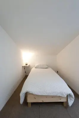 a bedroom with a bed in a white room at Gîte du Charme Provençal in Sénas
