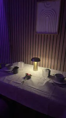 a table with plates and bowls and a lamp on it at Une Pause Douceur - Suite Orchidée in Eyguières
