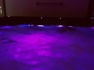 a pool of purple light in a dark room at Une Pause Douceur - Suite Orchidée in Eyguières