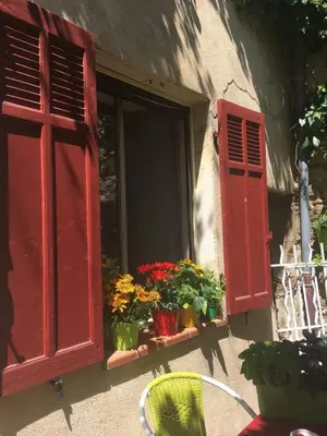 a red window with flowers and plants on a window sill at Havre de paix en Provence in Lauris