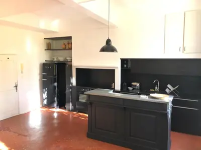 a kitchen with black appliances and a black counter top at Beau 3 pièces 83 m2 au coeur du centre historique d'Aix en Provence in Aix-en-Provence