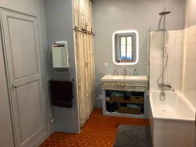 a bathroom with a tub and a sink and a mirror at Beau 3 pièces 83 m2 au coeur du centre historique d'Aix en Provence in Aix-en-Provence