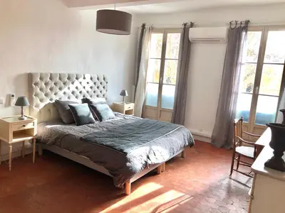 a bedroom with a large bed and two windows at Beau 3 pièces 83 m2 au coeur du centre historique d'Aix en Provence in Aix-en-Provence