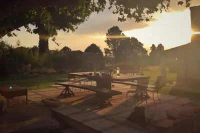 a picnic table in a backyard with the sun setting at Mas de L Angeos in Velleron