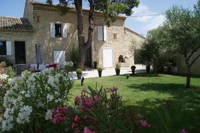 a garden in front of a stone house with flowers at B&B dans Mas en pierres in Robion en Luberon
