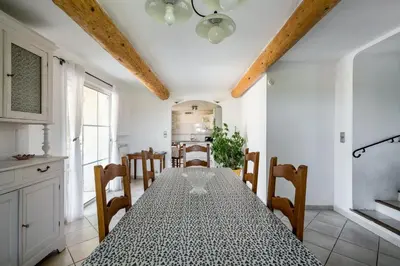 a kitchen and dining room with a table and chairs at Villa charmante à La Tour-d'Aigues avec piscine privée in La Tour-dʼAigues