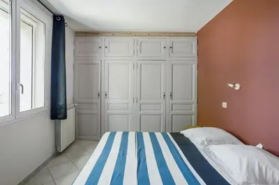 a bedroom with a bed with blue and white stripes at Villa charmante à La Tour-d'Aigues avec piscine privée in La Tour-dʼAigues