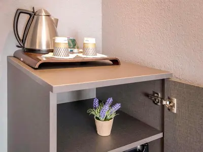 a laptop computer sitting on a desk with a mirror at Mercure Cavaillon in Cavaillon