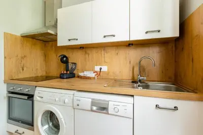 a kitchen with a sink and a washing machine at La Bastide de l Etang in LʼIsle-sur-la-Sorgue