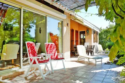 a patio with chairs and a table and windows at Holiday Home near Mont Ventoux Ski Resort in Bédoin
