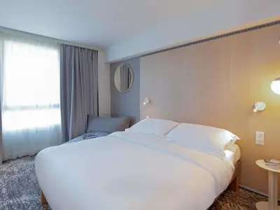 a large white bed in a hotel room at Novotel Aix-en-Provence Pont de L'Arc in Aix-en-Provence