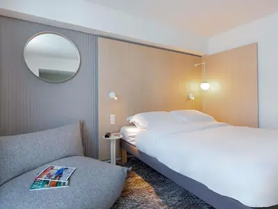 a bedroom with a large white bed and a mirror at Novotel Aix-en-Provence Pont de L'Arc in Aix-en-Provence