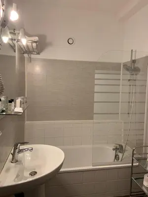 a bathroom with a sink and a bath tub at The Originals Boutique, Hôtel du Parc, Cavaillon in Cavaillon