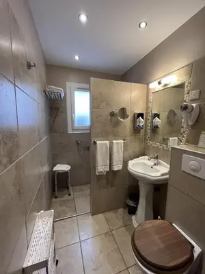 a bathroom with a sink and a toilet and a shower at The Originals Boutique, Hôtel du Parc, Cavaillon in Cavaillon