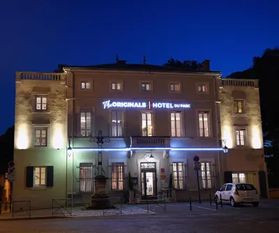 a building with a white car parked in front of it at The Originals Boutique, Hôtel du Parc, Cavaillon in Cavaillon