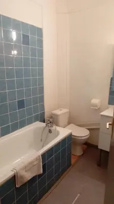a bathroom with a white toilet and a tub and a sink at Hôtel Du Cours in Pertuis