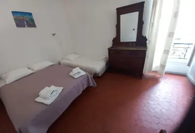 a room with two beds and a mirror in it at Hôtel Du Cours in Pertuis