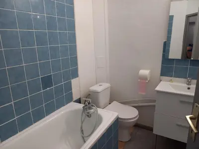 a bathroom with a toilet and a tub and a sink at Hôtel Du Cours in Pertuis