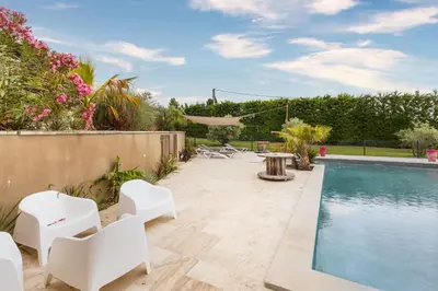 a backyard with a swimming pool and white chairs at Mas Carla in Noves