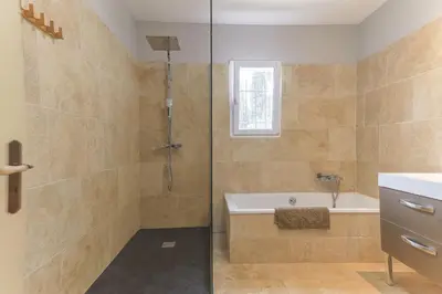 a bathroom with a shower with a tub and a sink at Mas Carla in Noves