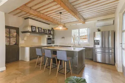 a kitchen with a large island with bar stools at Mas Carla in Noves