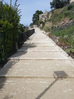 an empty road with a house on a hill at Chambre d'hôte Geiko in Cabrières-dʼAigues