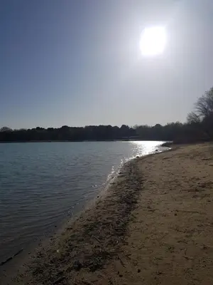a beach with the sun reflecting on the water at Chambre d'hôte Geiko in Cabrières-dʼAigues