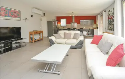 a living room with white couches and a tv at Awesome Home In Saint-Rémy-De-Provence in Saint-Rémy-de-Provence