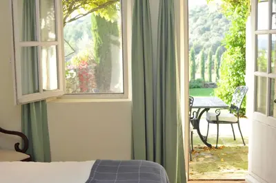 a bedroom with a bed and a window and a table at Mas de Michel in Bonnieux