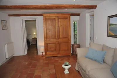 a living room with a couch and a wooden door at Mas de Michel in Bonnieux