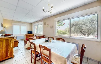 a dining room with a table and a large window at 2 Bedroom Gorgeous Apartment In Caromb in Caromb