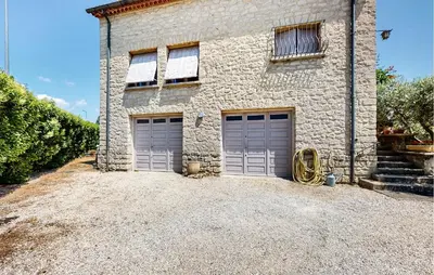 a stone building with two garage doors on it at 2 Bedroom Gorgeous Apartment In Caromb in Caromb