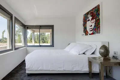 a white bedroom with a bed and a table at Mas de Panière - Saint Remy de Provence in Paluds de Noves