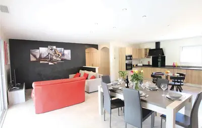 a dining room and living room with a table and chairs at Stunning Home In Monteux in Monteux