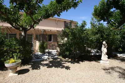 a garden with a statue in front of a house at CLOS DE LA FONT in Mollégès