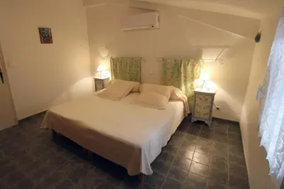 a bedroom with a white bed and two night stands at CLOS DE LA FONT in Mollégès