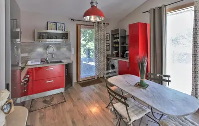 a kitchen with red cabinets and a table with chairs at Stunning Home In Saignon in Saignon