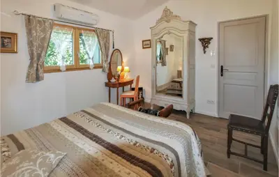 a bedroom with a bed and a mirror and a chair at Stunning Home In Saignon in Saignon