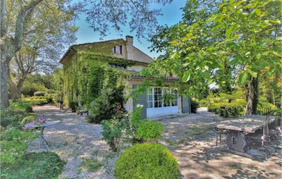 an ivy covered building with a picnic table in front of it at 4 Bedroom Stunning Home In Lagnes in Lagnes