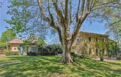a house with a large tree in the yard at 4 Bedroom Stunning Home In Lagnes in Lagnes