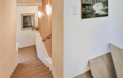 a hallway with a staircase with a bench and a painting at 4 Bedroom Stunning Home In Lagnes in Lagnes