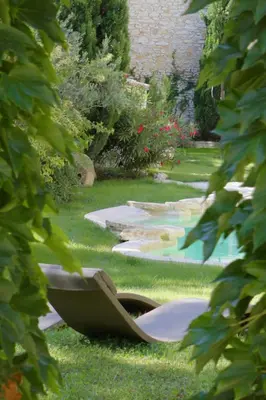 a bench sitting in the grass in a garden at Auberge Du Parc in Orgon